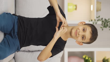 Vertical-video-of-Boy-making-heart-symbol-for-camera.